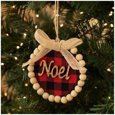 a christmas ornament with the word noel on it hanging from a christmas tree