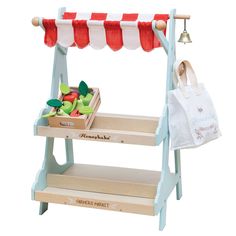 a wooden stand with fruit on it and a shopping bag hanging from the top shelf