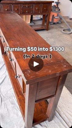 a wooden table sitting on top of a white sheet covered floor next to a dresser