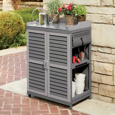 an outdoor storage cabinet with flowers and gardening tools