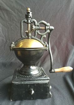 an old fashioned coffee grinder sitting on top of a table