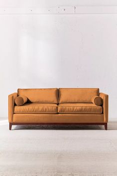 an orange couch sitting on top of a white floor