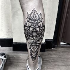 a man's leg with a black and white tattoo on it