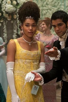 a man in a tuxedo standing next to a woman in a yellow dress