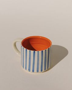 a blue and white striped cup sitting on top of a table