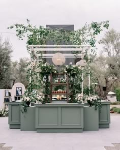 an outdoor bar with flowers and greenery on it