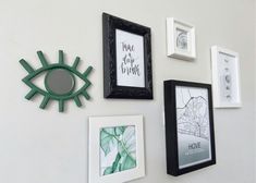 there are many pictures on the wall and one has an eye shaped decoration above it