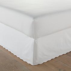 a white bed skirt with scalloped edges