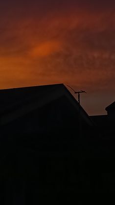 the sun is setting behind some houses