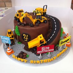 a birthday cake decorated with construction vehicles and road signs