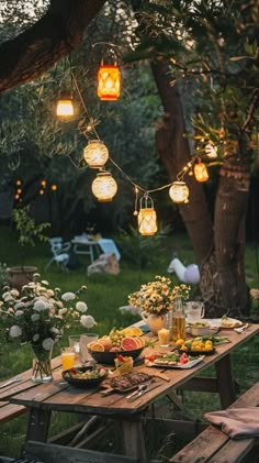 a picnic table with food and lights hanging from it