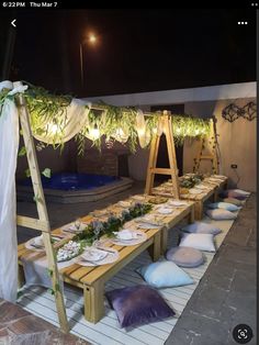 a long table set up with plates and pillows