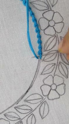 someone is stitching flowers on a piece of fabric