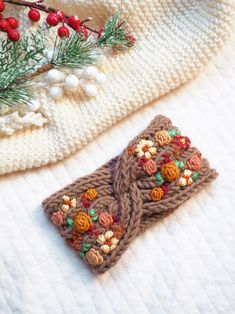 a crocheted wallet sitting on top of a white blanket next to a christmas tree