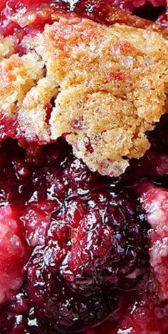 a close up of a berry pie with crumbs on the top and bottom