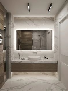 a modern bathroom with marble counter tops and white walls, lighted by recessed lights