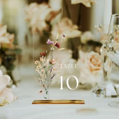 the table numbers are displayed with flowers in vases and wine glasses on the table