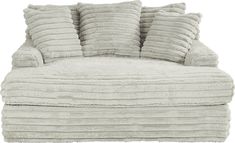 a white couch with five pillows stacked on it's back and one sitting in the middle