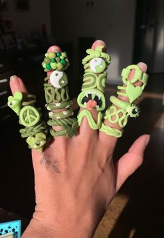 someone is holding their fingers in the shape of five finger rings with faces on them