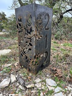 a metal box sitting on top of a field covered in grass and leaves with numbers carved into it