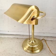 a gold desk lamp on a white wooden floor