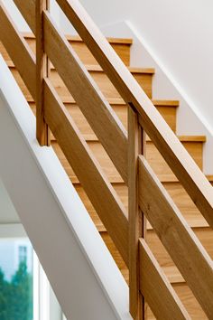 an open staircase with wooden handrails and white walls