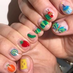 a person holding their hands with different nail designs on them and the fingers are decorated with fruits and vegetables