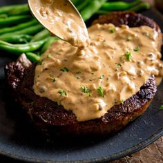 a fork is being used to dip sauce on a steak