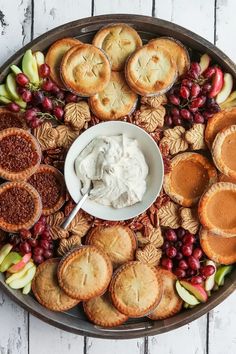 a platter filled with pies, crackers and fruit