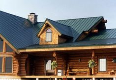 a large log house with a green roof