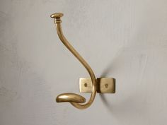 a gold hook on a white wall