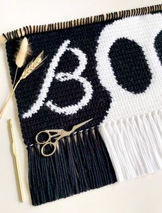 scissors, thread, and yarn laid out on top of a black and white blanket