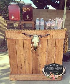 a wooden crate filled with drinks and some cow's head on the side of it