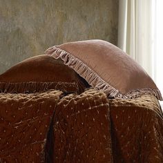 a bed with two pillows on top of it next to a window in a room