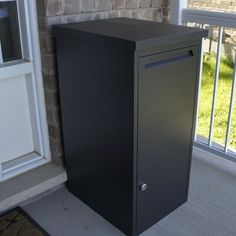 a black mailbox sitting in front of a window