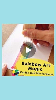 someone is holding a toothbrush in front of a piece of paper that says rainbow art magic cotton bud masterpiece