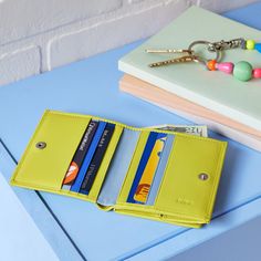 a yellow wallet sitting on top of a blue table next to a pair of keys