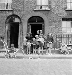 a group of children standing in front of a brick building