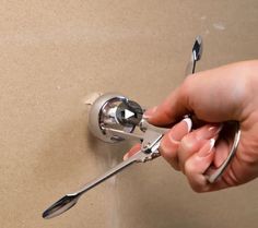 a person holding a pair of pliers in their hand while fixing a sink faucet