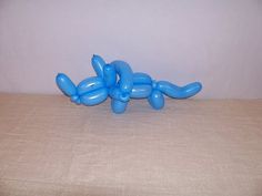 an inflatable balloon dog laying on top of a bed next to a wall