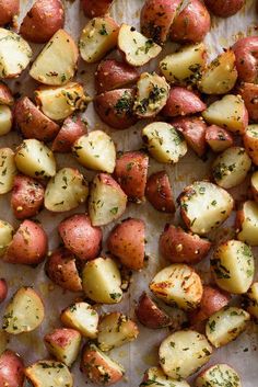 roasted potatoes with herbs and seasoning on a baking sheet