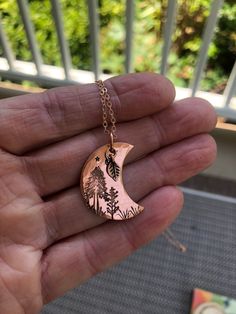 This is a 1 1/4" copper moon hand-stamped pendant. This is shiny copper (non-antiqued).  A tiny copper leaf has been attached. I have hand stamped a little night forest scene, with several trees, grass, and a tiny moon and stars. The copper has been sealed with an archival wax, but over time since this is copper, it will develop a lovely patina. To maintain its shine as it is now, I will include a little polishing cloth. This pendant includes an 18" lovely sparkly dainty rose gold chain. Someone who loves the outdoors and nature would love this pendant! Copper Pendant Necklace, Copper Pendant, Copper Wire Crafts, Copper Work, Rose Gold Chain, Copper Metal, Copper Pendants, Wire Crafts, Metal Pendant