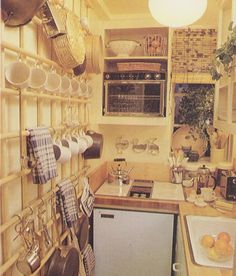 a small kitchen with pots and pans hanging on the wall above the dishwasher