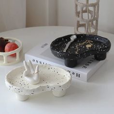 a white table topped with two black and white dishes