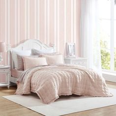 a bedroom with pink walls and white furniture