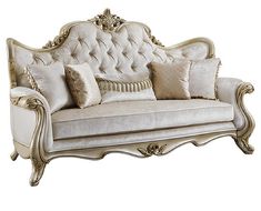 a white couch with gold trimmings and pillows on top of it's back