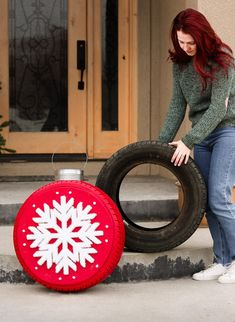 a woman standing next to a tire with a snowflake on it