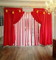 a red and white striped curtain is in the middle of a room with chandelier