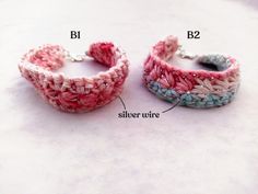 two crocheted bracelets sitting next to each other