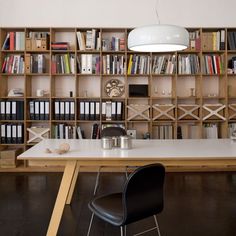 a table and chairs in front of a book shelf with books on the shelves behind it